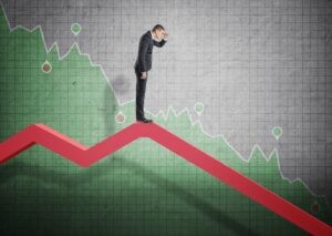 Businessman standing on falling diagram and peering into the future Osoba patrząca na trudna przyszłość firmy